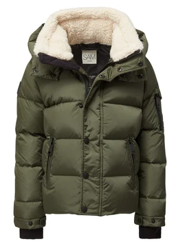 A toddler boys puffer jacket in olive green with a plush cream sherpa lining visible at the hood and collar. Designed for chilly weather, it features a detachable-looking hood, a front zipper with a snap storm flap, and zippered side pockets; ribbed black cuffs and hem provide a snug fit. The quilted, padded exterior suggests a warm, insulated winter coat for young boys.