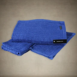 Blue ribbed cotton towel set (bath towel, hand towel, washcloth) with a black Members Only tag, displayed on a neutral surface.