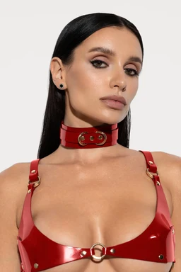 Shiny red patent leather choker collar with gold D-rings, modeled with matching red harness bralette.