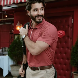 A man in the Clubhouse Pique Polo Red Brick line, outdoor setting