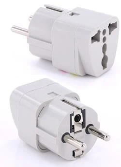 Two grey plastic travel plug adapters, one showing multi-hole socket face and the other showing two round prongs, on a white background.