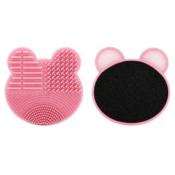 Two pink bear-shaped silicone makeup brush cleaning pads, one with textured ridges and the other with a black suede-like drying surface, shown on a white background.