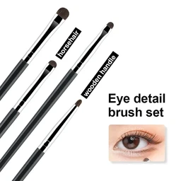 Four slim black makeup brushes with wooden handles and horsehair tips are arranged diagonally against a white background, with a small photo of a closed eye with brown eyeshadow in the lower right.