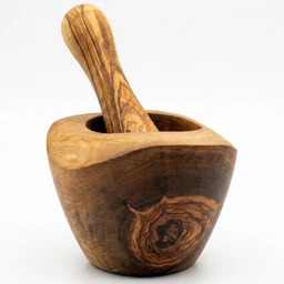 A rustic olive wood mortar and pestle with warm honey-brown grain and dark knots, set against a plain white background.