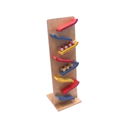 A tall wooden toy tower with a light wood frame holding five colourful curved red, blue and yellow tracks, with small wooden cylinder rollers on two of the tracks, set on a flat wooden base against a white background.