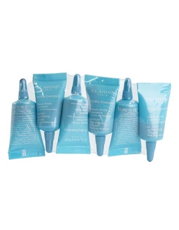 Six small light-blue tube-shaped sample packs with white Clarins labels and nozzle tips are arranged in two staggered rows on a white background.