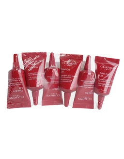 Six small red foil sachets labelled Clarins Total Eye Lift lie fanned out on a white background, each with a dropper-style tip.
