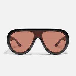 These are oversized shield-style sunglasses with a single continuous brown frame and gradient lenses. The lenses fade from a darker brown at the top to a lighter amber at the bottom, set in a warm brown plastic frame. The look is bold and modern, likely unisex in appeal.