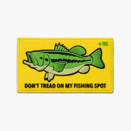 A rectangular embroidered patch with a bright yellow background. It features a green largemouth bass graphic and bold black text reading “DON'T TREAD ON MY FISHING SPOT.” Likely intended for fishing enthusiasts (unisex), with a cartoon-style image and a stitched border. Material appears to be a rubber/PVC-style patch suitable for clothing or gear.