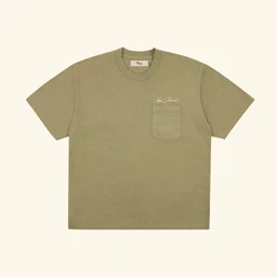 A dusty olive cotton crewneck T-shirt with a single left chest pocket and a subtle washed finish. The fit and styling suggest a casual, unisex/men’s silhouette with a relaxed, boxy cut. Notable details include the small script accent above the pocket and the cactus-toned color.